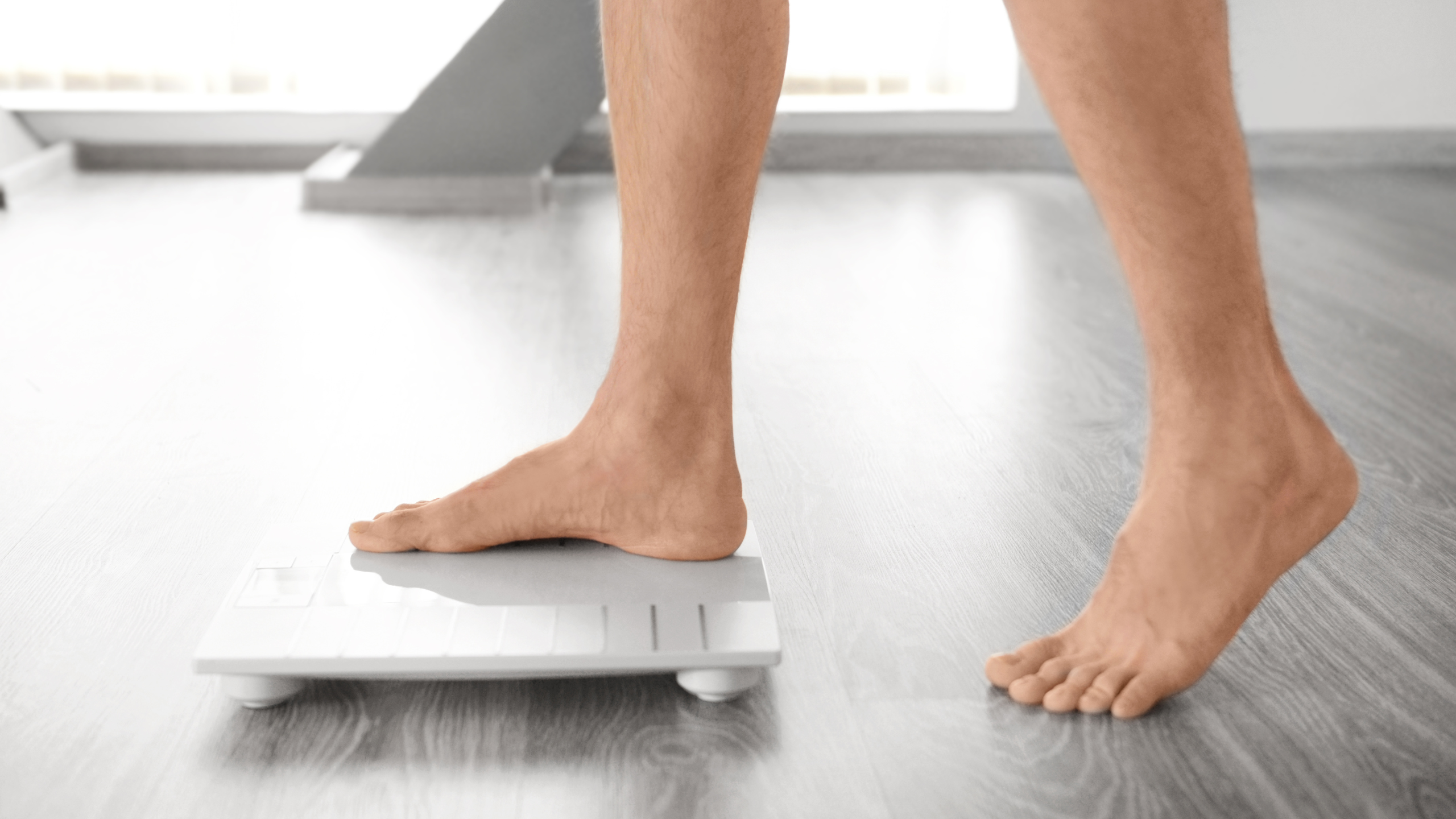 man stepping on a white scale