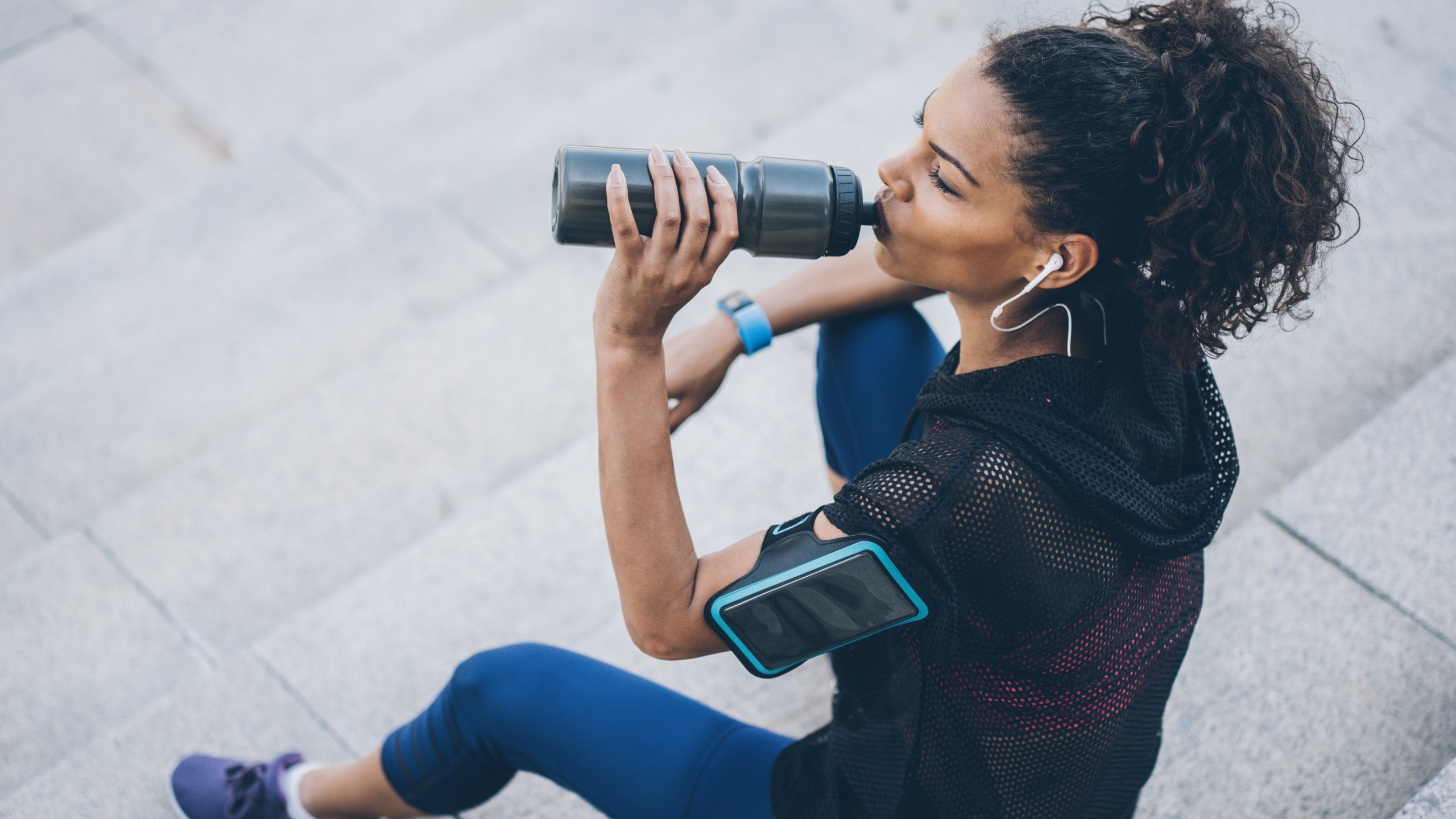 woman drinking from a water bottle