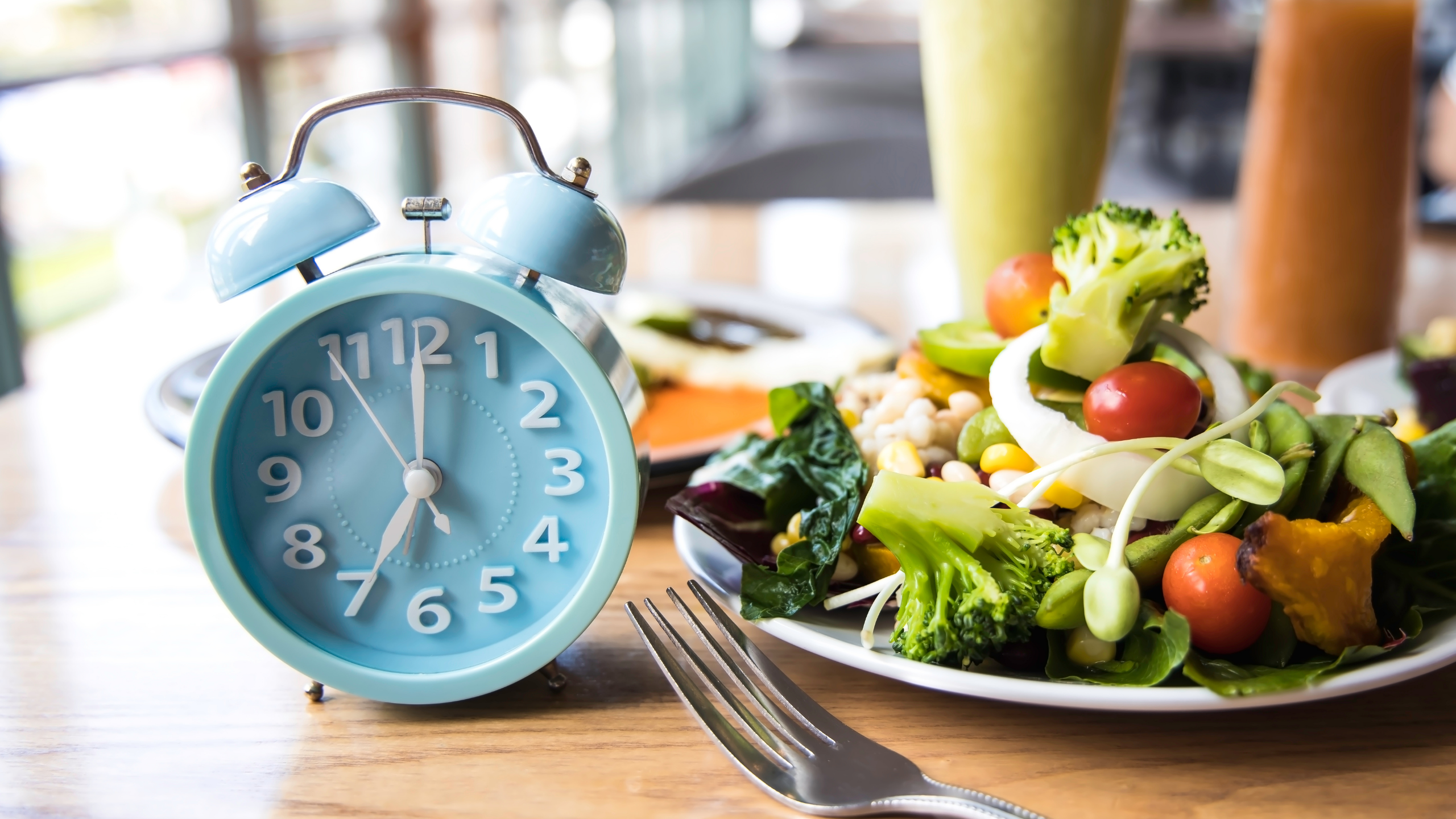 timing intermittent fasting with a salad and drinks in the background