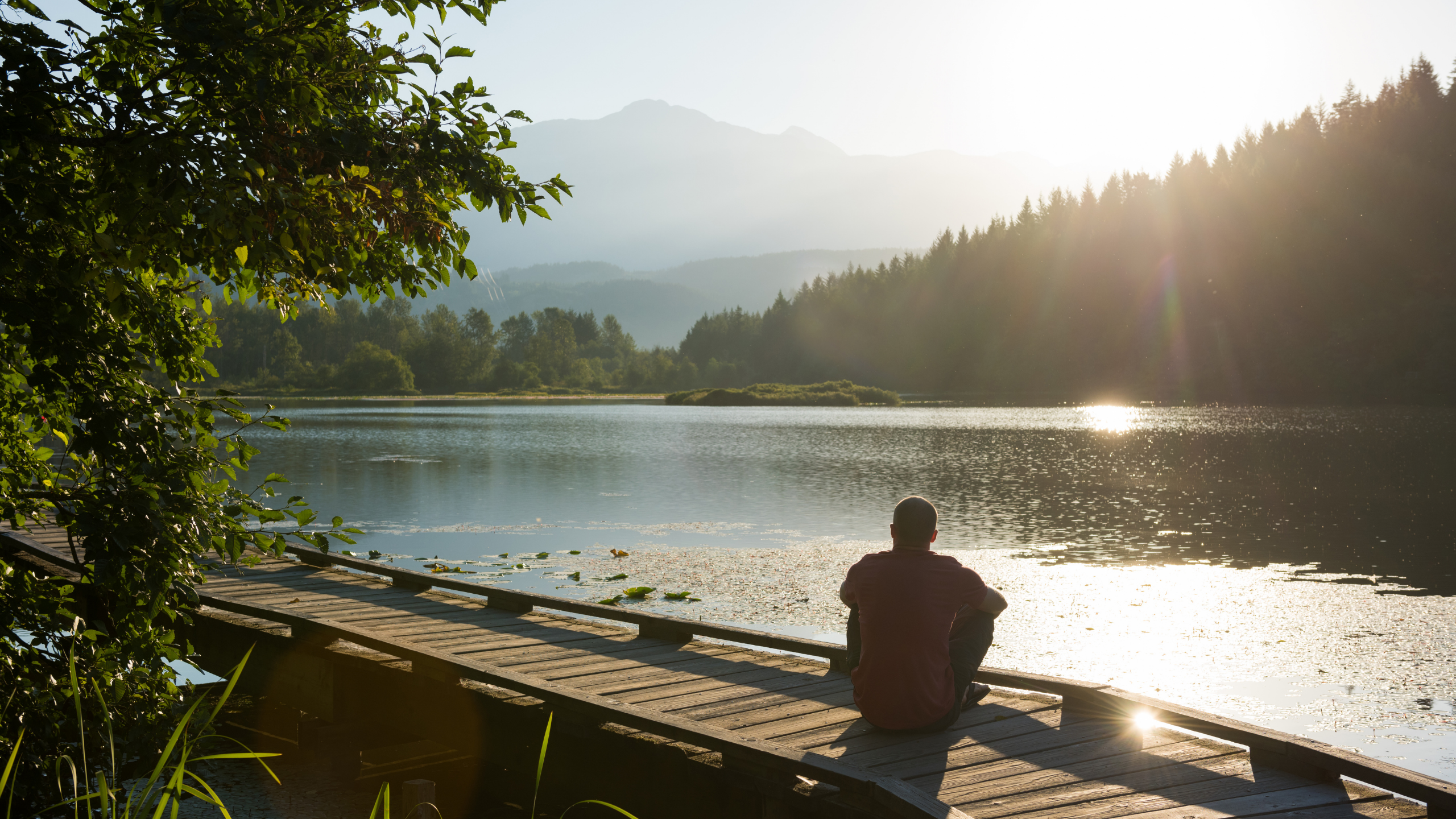 man sitting by a lake