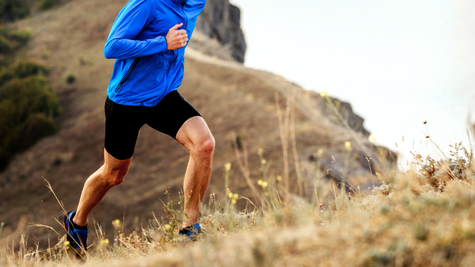 Man running on a grassy hill