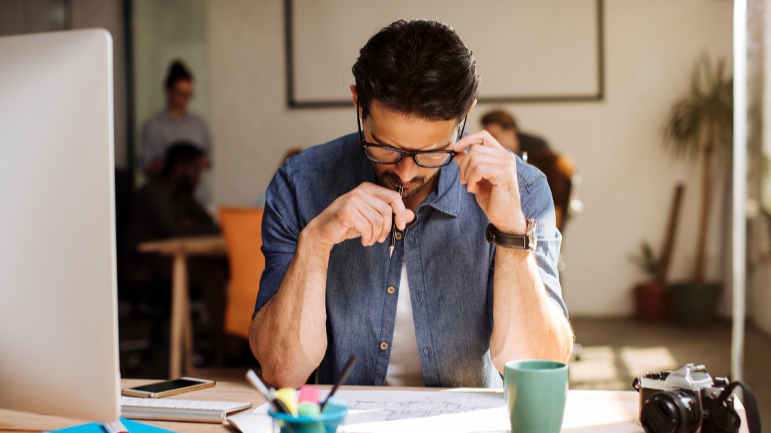 man concentrating at a document on his desk