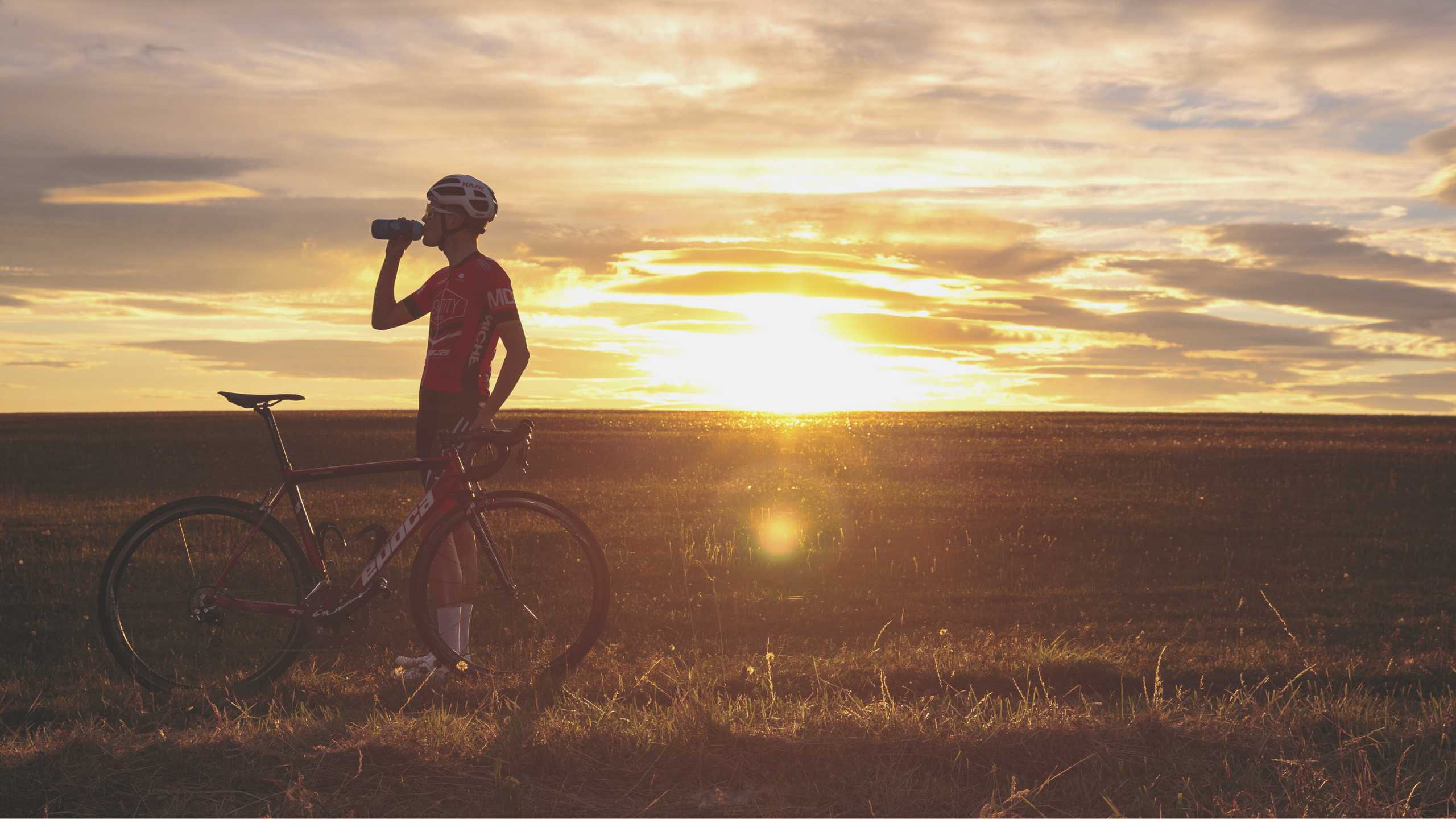 man on bike drinking water