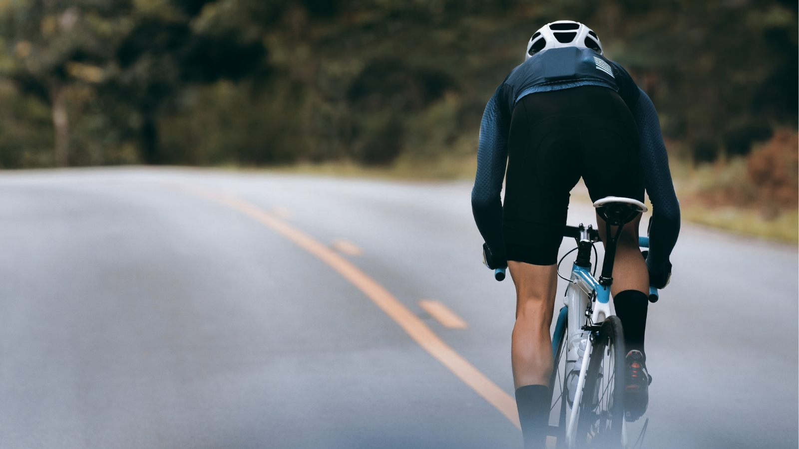 Back of a cyclist cycling on a road