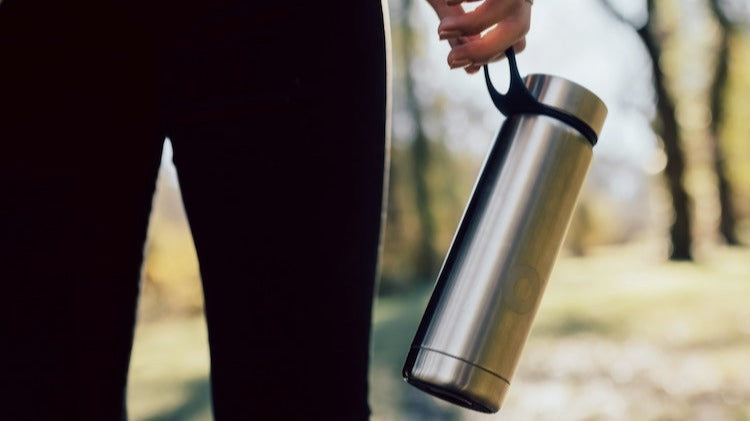 Athlete with water bottle on a trail