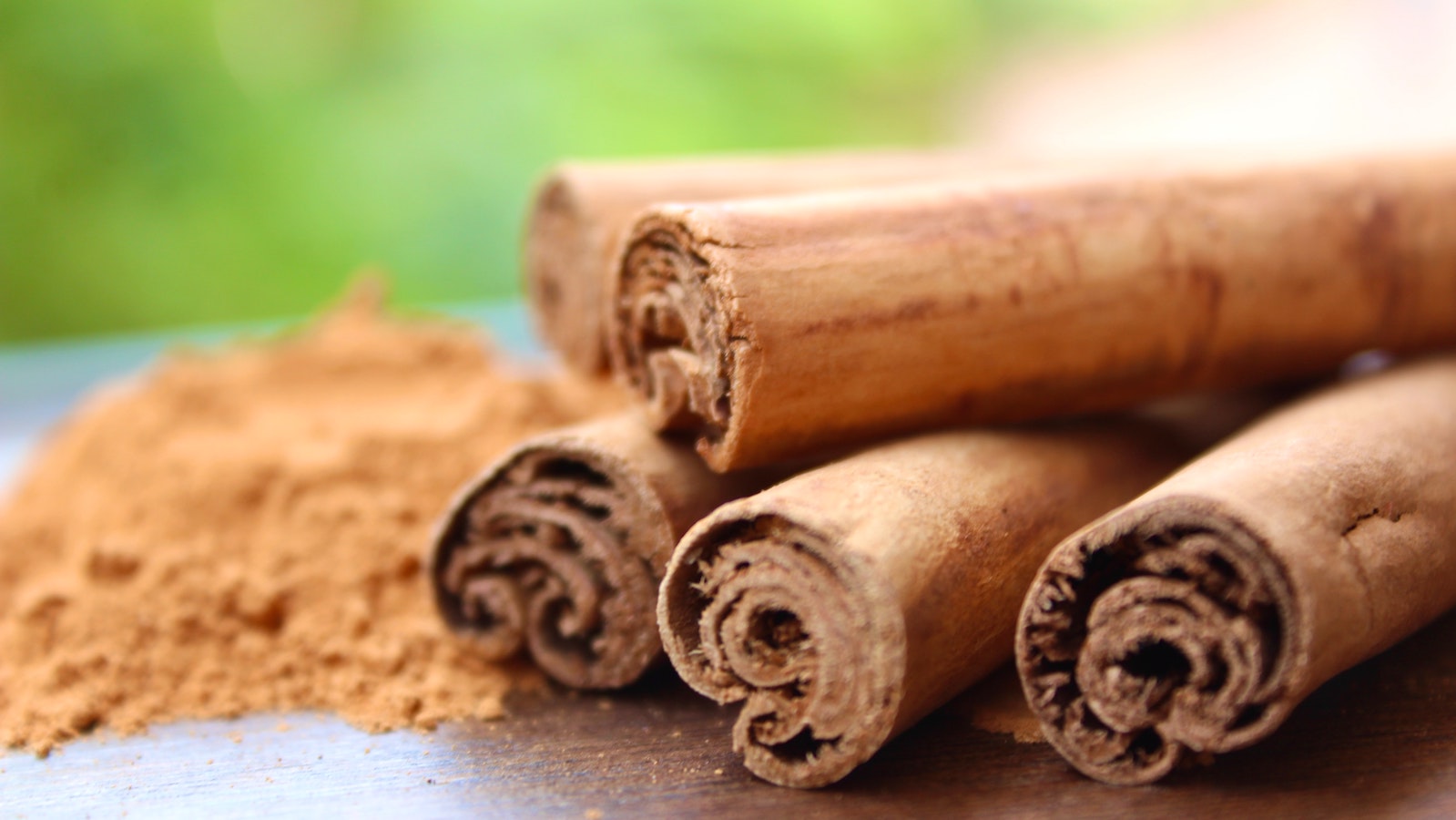 Cinnamon stick pile with cinnamon spice on table outside 