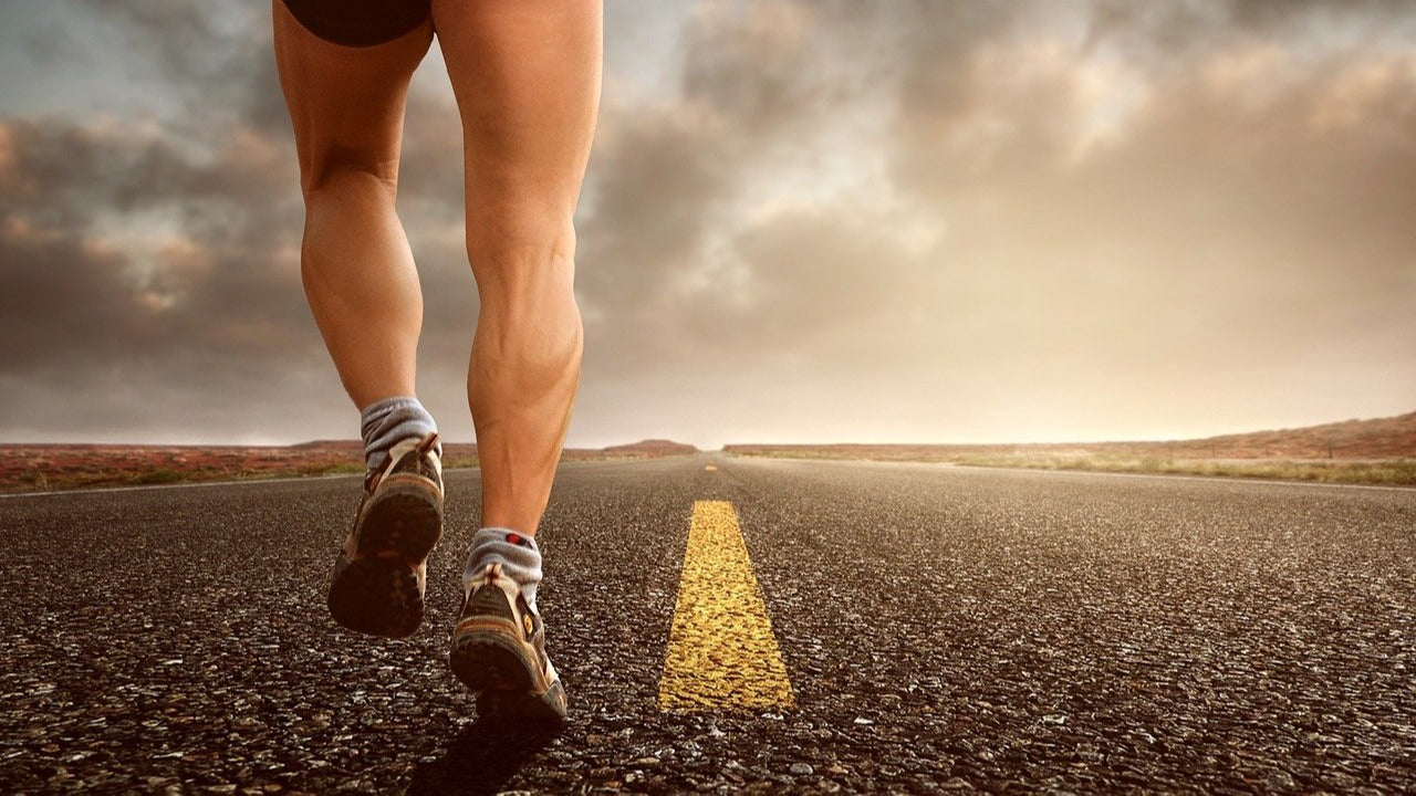 runner in black shorts running on a road