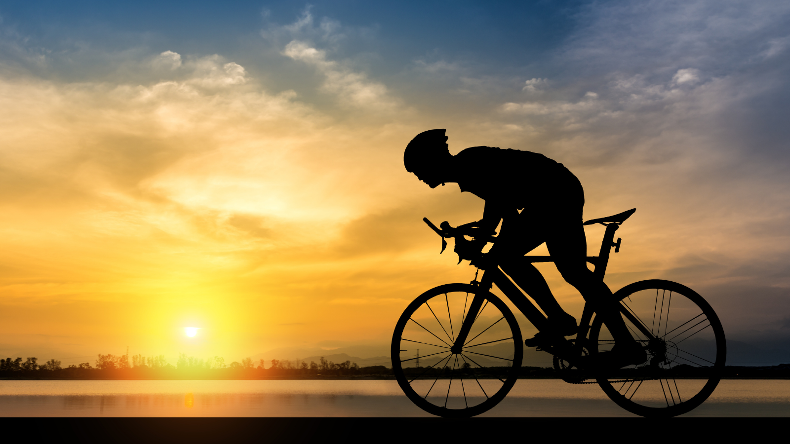 silhouette of a cyclist with city in the background